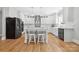 Modern white kitchen featuring a large island with seating, pendant lights, and stainless steel appliances at 29268 Pennington Rd, Albemarle, NC 28001
