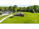 Expansive green lawn surrounds a beautiful brick home, complete with an in-ground pool and mature trees in a serene setting at 3003 Eaker Dr, Cherryville, NC 28021