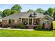 Charming brick home features a manicured lawn, welcoming front porch, and dormer window, creating a picturesque curb appeal at 3003 Eaker Dr, Cherryville, NC 28021