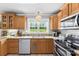Bright kitchen featuring granite countertops, stainless steel appliances, and natural wood cabinets at 3003 Eaker Dr, Cherryville, NC 28021