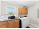 Functional laundry room with washer, dryer, storage cabinets, and large window at 3003 Eaker Dr, Cherryville, NC 28021