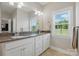 Bright bathroom with double sinks, granite counters, and a window offering scenic views at 3013 Isle Ln, Monroe, NC 28110