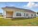 Backyard view featuring a covered patio and large windows providing lots of light into the home at 3013 Isle Ln, Monroe, NC 28110