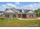 Charming brick home boasts a well-manicured lawn and a welcoming front porch, perfect for relaxing at 3013 Isle Ln, Monroe, NC 28110