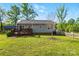 Backyard view of home featuring a wooden deck, sliding glass door, grassy lawn, and outbuilding at 303 Caroline Ave, Lowell, NC 28098