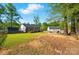 Large grassy backyard with deck, outbuilding and fire pit, perfect for outdoor activities at 303 Caroline Ave, Lowell, NC 28098