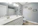 Bathroom with double sink vanity and updated fixtures, framed novelty prints, and tiled floor at 303 Caroline Ave, Lowell, NC 28098