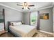 Calm bedroom with a soft gray color scheme, ceiling fan, and natural light at 303 Caroline Ave, Lowell, NC 28098