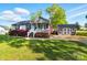 A well-maintained home featuring a charming front porch, landscaped lawn, and a shed in the background at 303 Caroline Ave, Lowell, NC 28098