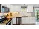 Bright kitchen with stainless steel appliances, granite countertops, and ample storage space at 303 Caroline Ave, Lowell, NC 28098