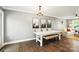 Bright living room with wooden floors, white dining table, and decorative nature wall art at 303 Caroline Ave, Lowell, NC 28098