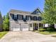 Charming two-story home with a well-manicured lawn, three-car garage and covered front porch at 3057 Drummond Ave, Indian Land, SC 29707