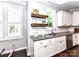 The kitchen features granite counters, a stainless steel dishwasher, and wood floating shelves next to the window at 3057 Drummond Ave, Indian Land, SC 29707