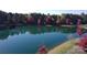 An aerial view of a tranquil pond surrounded by colorful autumn foliage, creating a serene landscape at 3057 Drummond Ave, Indian Land, SC 29707
