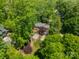 Stunning aerial view of wooded home with lush landscaping, patio, and deck at 3233 Sunnymede Ln, Charlotte, NC 28209