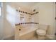 Bathroom with a tiled shower-tub combo and white toilet at 3233 Sunnymede Ln, Charlotte, NC 28209