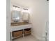 Bathroom featuring double sinks, granite countertops, and decorative baskets for storage at 3233 Sunnymede Ln, Charlotte, NC 28209