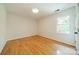 Empty bedroom with wood floors, neutral paint, crown molding, and one window at 3233 Sunnymede Ln, Charlotte, NC 28209