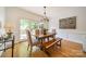 Inviting dining area with hardwood floors, modern chandelier, and access to the outdoor deck at 3233 Sunnymede Ln, Charlotte, NC 28209