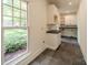 Well-organized laundry room with ample cabinet space, countertop, and a large window at 3233 Sunnymede Ln, Charlotte, NC 28209