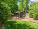Backyard view of shed featuring a grassy area, storage building, and surrounding trees at 3233 Sunnymede Ln, Charlotte, NC 28209