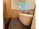 Bathroom with a sleek standalone tub complemented by wood-paneled walls and modern fixtures at 3317 Sargeant Dr, Charlotte, NC 28217