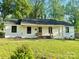 Charming exterior of a one-story home featuring a well-kept lawn and a cozy front porch with wooden columns at 3317 Sargeant Dr, Charlotte, NC 28217