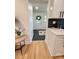 Inviting hallway showcases wood floors, stylish decor, and access to a white door with decorative wreath at 3317 Sargeant Dr, Charlotte, NC 28217