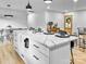 Kitchen island featuring a marble countertop with black fixtures and a view into the living and dining areas at 3317 Sargeant Dr, Charlotte, NC 28217
