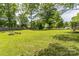Expansive backyard featuring a fire pit and mature trees, perfect for outdoor entertaining and relaxation at 3619 Baywoods Ct, Gastonia, NC 28056