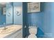 Bathroom with blue paint and small sink with mirror above the toilet at 3619 Baywoods Ct, Gastonia, NC 28056