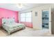 Bedroom with bright pink accent wall, neutral carpet, and large window at 3619 Baywoods Ct, Gastonia, NC 28056