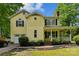 Charming two-story yellow home featuring a covered front porch and attached garage at 3619 Baywoods Ct, Gastonia, NC 28056