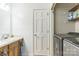 Well-lit laundry area with washer, dryer, storage shelves, and a sink at 3619 Baywoods Ct, Gastonia, NC 28056