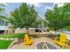 Backyard featuring a stone firepit, yellow Adirondack chairs, and a landscaped yard at 365 Delburg St, Davidson, NC 28036