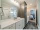 Bathroom with double sinks, vanity, and a glass enclosed shower at 365 Delburg St, Davidson, NC 28036