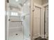 Tiled walk-in shower featuring white subway tile, a shower seat, and a glass door at 365 Delburg St, Davidson, NC 28036