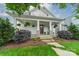 Charming home featuring a welcoming front porch with stone accents and lush landscaping at 365 Delburg St, Davidson, NC 28036