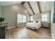 Bright main bedroom with vaulted ceiling, wooden beams, and neutral color palette at 365 Delburg St, Davidson, NC 28036