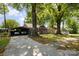 View of a single-story house, a detached carport, a parked car in the driveway and mature trees at 3919 Sarah Dr # 14, Charlotte, NC 28217