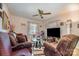 A cozy living room with comfortable seating, a ceiling fan, a large TV and a glass coffee table at 3919 Sarah Dr # 14, Charlotte, NC 28217