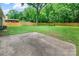 Spacious backyard features a concrete patio, a tall tree, and a wooden fence at 4009 Dunwoody Dr, Charlotte, NC 28215