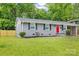 A well-maintained single-story home features a gray exterior, black shutters, and a vibrant red front door at 4009 Dunwoody Dr, Charlotte, NC 28215