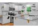 Well-lit kitchen boasts white cabinets, granite counters, and stainless steel appliances, blending style and functionality at 4009 Dunwoody Dr, Charlotte, NC 28215