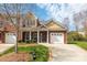 Charming brick townhome with manicured front yard, front-entry two-car garage, and a cozy front porch at 4015 Broadview Ln, Gastonia, NC 28056