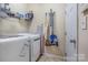 Functional laundry area with modern appliances, shelving for storage, and ample space for cleaning supplies at 4015 Broadview Ln, Gastonia, NC 28056