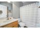 Well-lit bathroom with a wood vanity and shower with a white and blue striped curtain at 503 Azure Ave, Albemarle, NC 28001