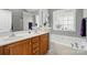 Clean main bathroom featuring double sinks, a large soaking tub, and a bright window for natural light at 503 Azure Ave, Albemarle, NC 28001