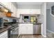 Modern kitchen features white cabinets, dark countertops, and stainless steel appliances, next to the living room at 513 Lex Dr, Charlotte, NC 28262