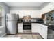 Well-equipped kitchen with stainless steel appliances, white cabinetry, and wood-look flooring at 513 Lex Dr, Charlotte, NC 28262